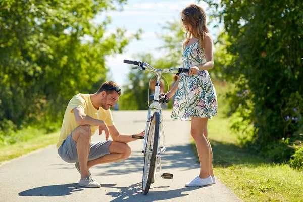 Heureux jeune couple fixer vélo sur la route de campagne — Photo