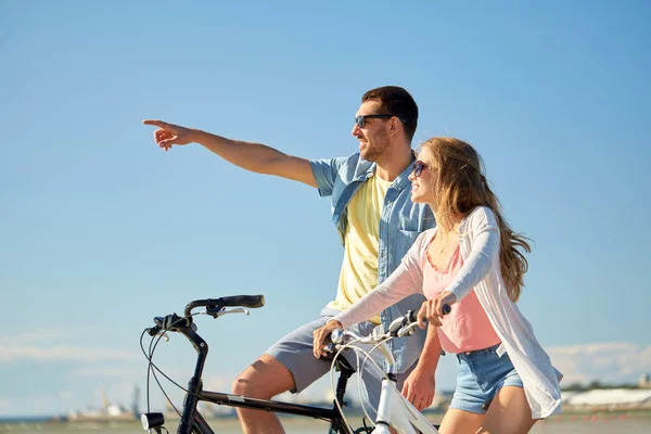 Feliz casal jovem andar de bicicleta à beira-mar — Fotografia de Stock
