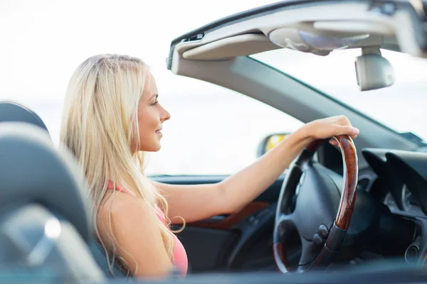 Happy young woman driving convertible car — Stock Photo, Image