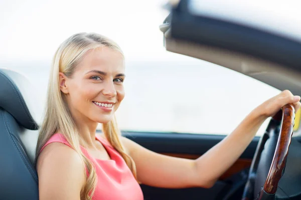 Happy young woman driving convertible car — Stock Photo, Image