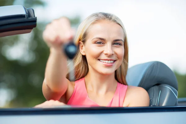 Happy young woman with convertible car key — Stock Photo, Image