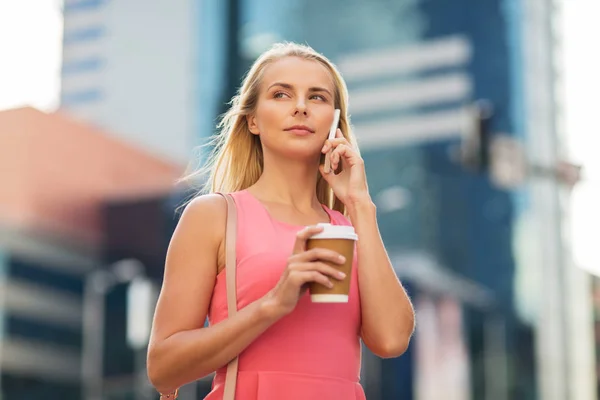 Жінка з викликом кави на смартфон у місті — стокове фото