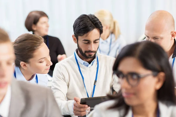 Team with tablet pc at business conference — Stock Photo, Image