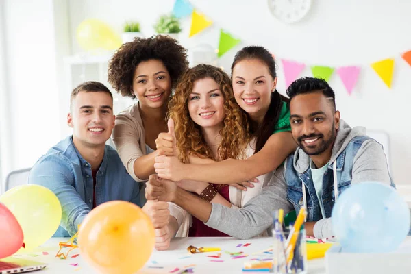 Happy team at office party showing thumbs up — Stock Photo, Image