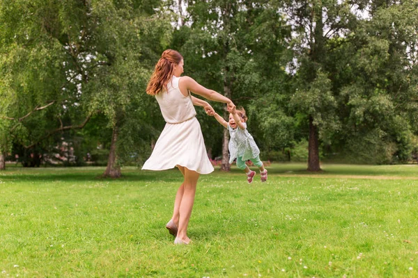 Lycklig mamma leker med flicka på sommaren park — Stockfoto