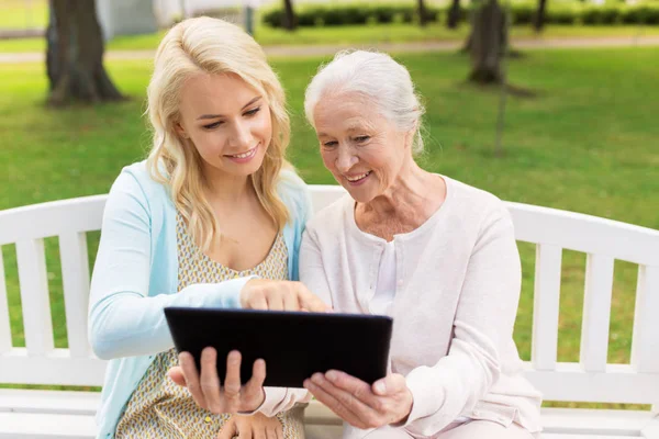 Dochter met tablet pc en senior moeder in park — Stockfoto