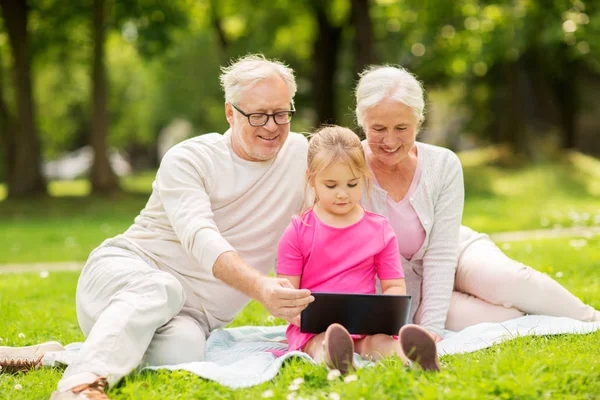 Großeltern und Enkelin mit Tablet-PC — Stockfoto