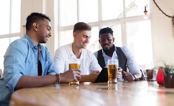 タブレット pc でビールを飲むと男性の友達バー — ストック写真