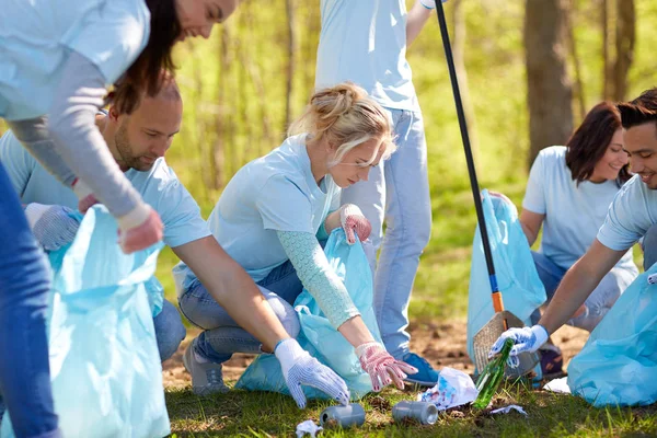 Voluntários com sacos de lixo área do parque de limpeza — Fotografia de Stock