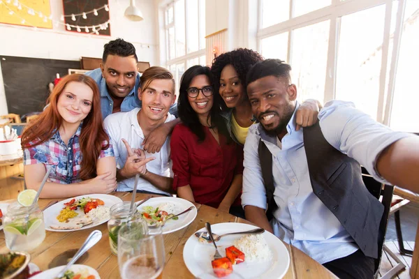 Szczęśliwy przyjaciele biorąc selfie w restauracji lub barze — Zdjęcie stockowe