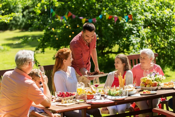 Happy family have food or summer garden party – stockfoto