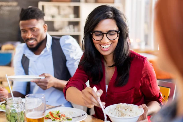 Happy friends eating at restaurant — Stock Photo, Image