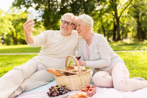 Senior paar nemen selfie op picknick in het park — Stockfoto