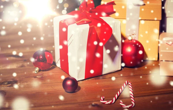 Cadeaux, bonbons et boules de Noël sur panneau en bois — Photo