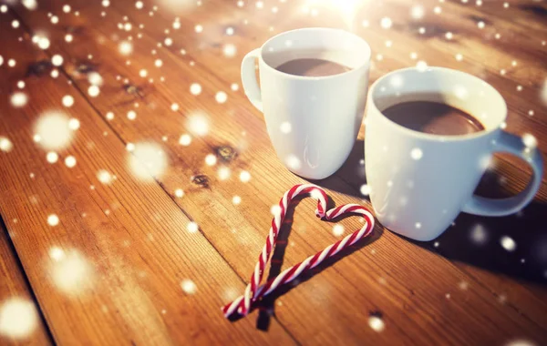 Bastones y copas de caramelo de Navidad en la mesa de madera — Foto de Stock