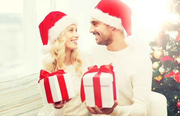 Feliz pareja en casa intercambiando regalos de Navidad —  Fotos de Stock