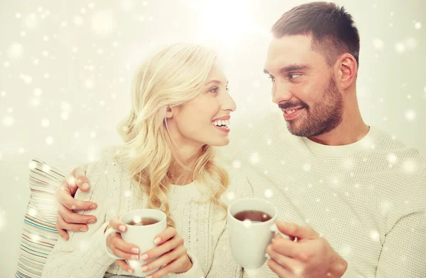 Happy couple with cups drinking tea at home — Stock Photo, Image
