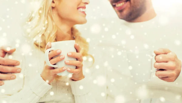 Close up of happy couple with tea cups at home — Stock Photo, Image