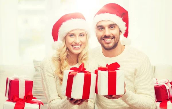 Heureux couple à la maison avec coffrets cadeaux de Noël Image En Vente