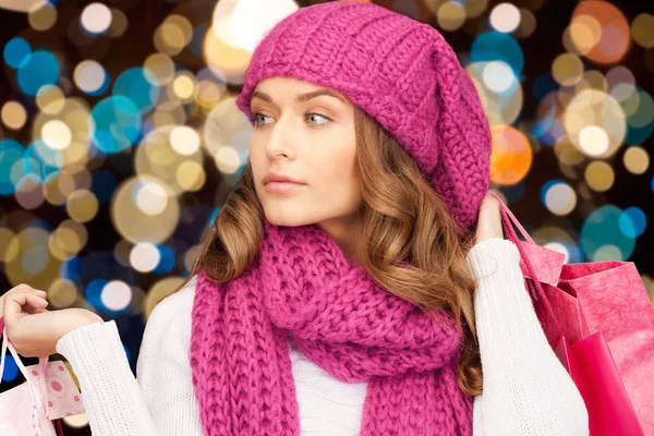 Vrouw in winter muts met kerst shopping tassen — Stockfoto