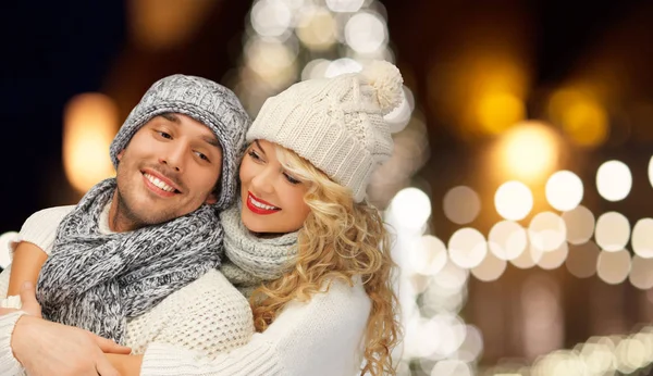 Feliz pareja abrazándose a través de luces de Navidad —  Fotos de Stock