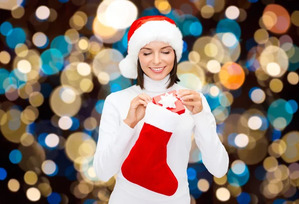 Mulher em santa chapéu com presente de Natal e meia — Fotografia de Stock