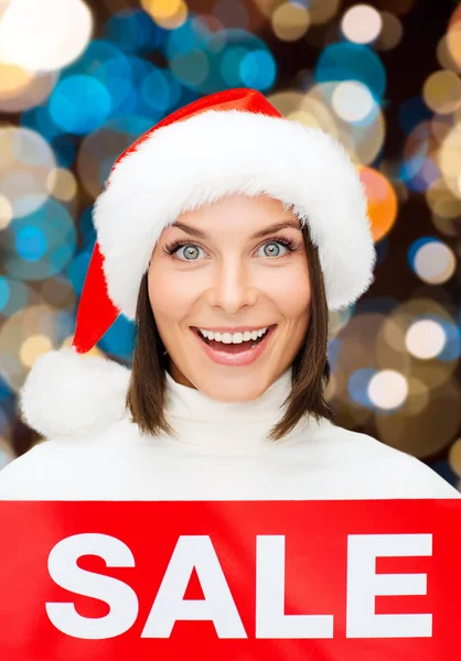Mulher feliz em santa chapéu com sinal de venda de natal — Fotografia de Stock