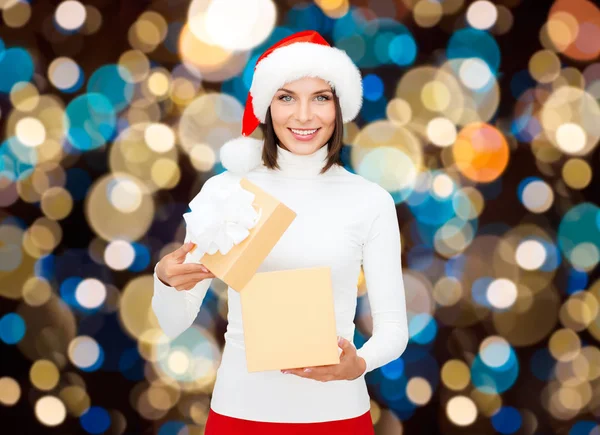 Sorrindo mulher em santa chapéu abrindo presente de Natal — Fotografia de Stock