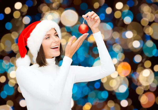 Mulher feliz em santa chapéu com bola de Natal — Fotografia de Stock