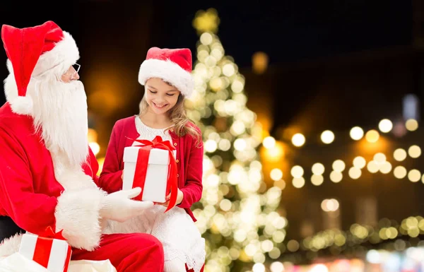 Jultomten och glad tjej med julklapp — Stockfoto