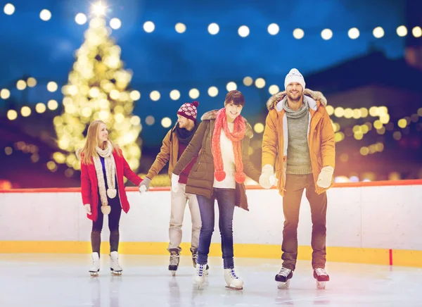 Gelukkig vrienden op kerst ijsbaan — Stockfoto