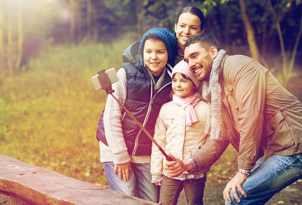 Famiglia felice con smartphone selfie bastone al campo — Foto Stock