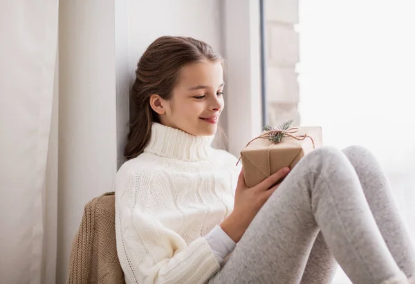 Mädchen mit Weihnachtsgeschenk sitzt zu Hause — Stockfoto