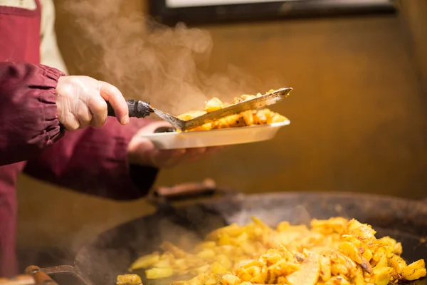 Cook with fried potato on plate and turner — Stock Photo, Image