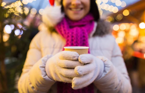 Mujer con taza de bebida caliente en el mercado de Navidad —  Fotos de Stock