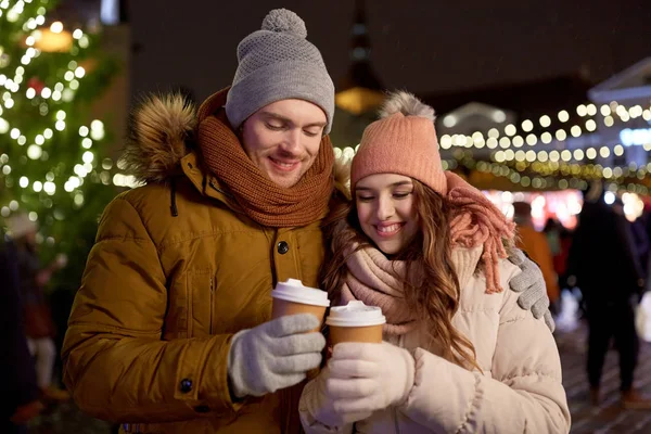 Heureux jeune couple avec café au marché de Noël — Photo