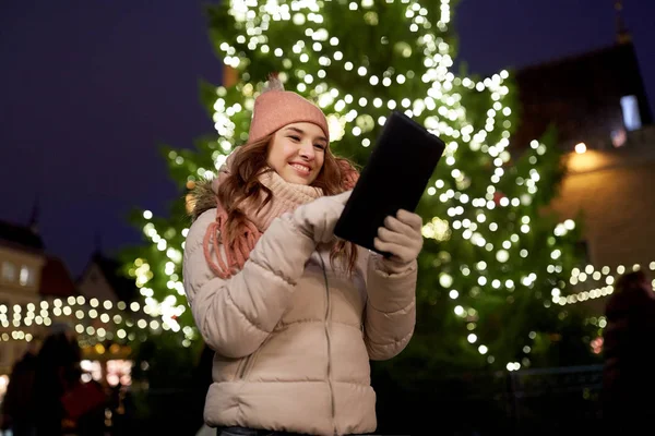 Γυναίκα με tablet pc στο χριστουγεννιάτικο δέντρο σε εξωτερικούς χώρους — Φωτογραφία Αρχείου