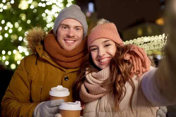 Пара с кофе делает селфи на Рождество — стоковое фото