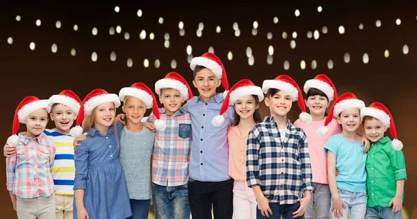 Szczęśliwy uśmiechający się dzieci w Boże Narodzenie santa kapelusze — Zdjęcie stockowe