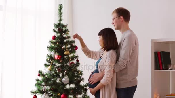 Boldog pár díszítő karácsonyfa otthon — Stock videók