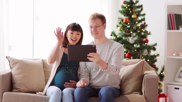 Man en zwangere vrouw met tablet pc met Kerstmis — Stockvideo