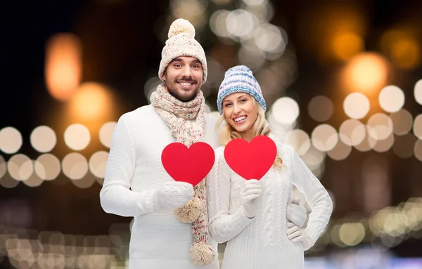 Couple avec des cœurs rouges sur les lumières de Noël — Photo