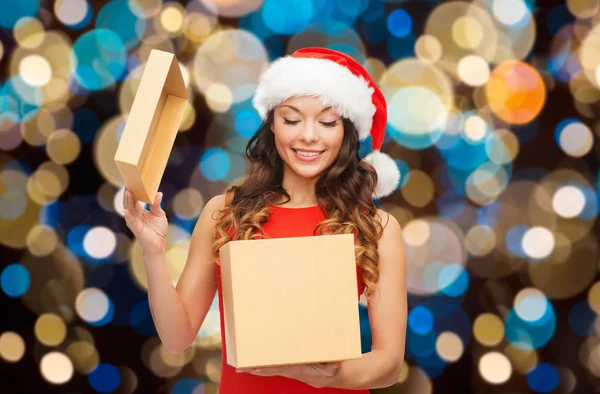 Smiling woman in santa hat opening christmas gift — Stock Photo, Image