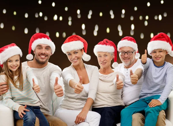 Family in christmas santa hats showing thumbs — Stock Photo, Image