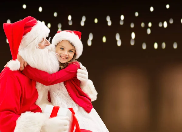 Papai Noel com presente de Natal e menina feliz — Fotografia de Stock