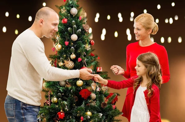 Lycklig familj dekorera julgran hemma — Stockfoto