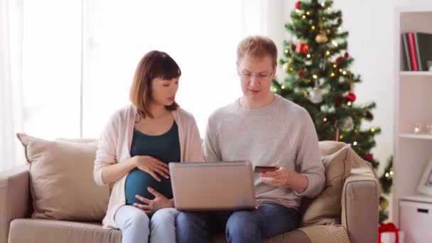 Мужчина и беременная жена делают покупки онлайн на Рождество — стоковое видео