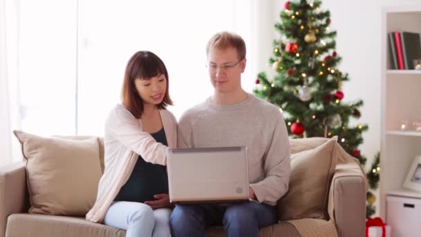 Man en zwangere vrouw met laptop met Kerstmis — Stockvideo