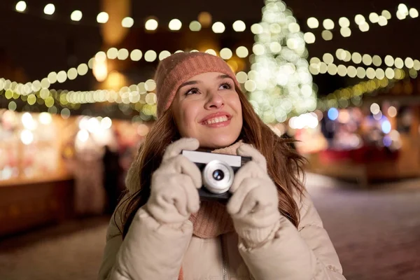 Ευτυχισμένος νεαρή γυναίκα με κάμερα στο Χριστουγεννιάτικη αγορά — Φωτογραφία Αρχείου