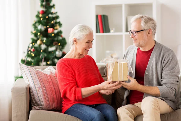 Щаслива усміхнена старша пара з різдвяним подарунком — стокове фото